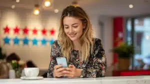 Woman using phone at cafe, relevant to multi-location local SEO strategies.